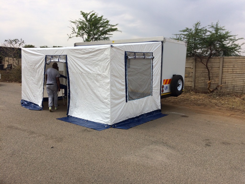 Portable laboratory trailer with tent extension deployed on rural roadside by LIS Labs.